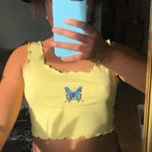 Gul top med en blå fjäril  - Säljer detta jätte söta linne 🦋😍 pris: 60kr + 30kr frakt