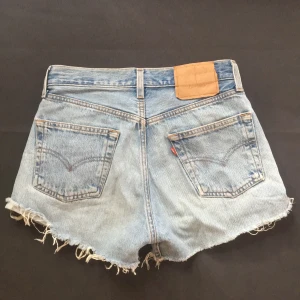 Levis jeansshorts - Klassiska Levisshorts. Flitigt använda därav avskaven text. Skulle påstå att de passar någon som är stl 36 om rumpan (det är jag). Fin blå tvätt. Säljer pga använder inte längre så har legat på vinden (därav lite vindsdoft som går bort i en tvätt)