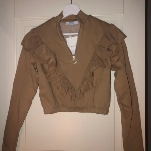 Volang tröja, S - Beige volang tröja, aldrig använd då jag nästan har en likadan. Strl S. Gosigt material på insidan och är riktigt snygg!