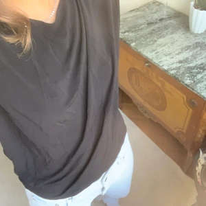 Svart T-shirt/blus - Den är t-shirten/ blusen är svart med en jättesnygg rygg. Toppen är från Filippa K och är i toppenskick. (Frakt tillkommer) Hör av er om ni är intresserade!