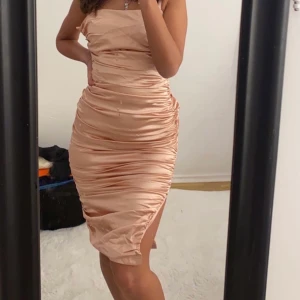 (HELT NY) Rosé Silkesklänning ”skrynklad” - XS/S  - Helt ny silkesklänning i färgen rosé. Passar både XS och S. Har en fin slits vid höger ben och har dragkedja på vänster sida av kroppen för att få fram ens figur mer. Skapar en ”timglaskropp” och ska vara ”skrynklig”. 