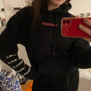 Svart Hoodie - Tryck på framsidan där det står ”THUGGER” i rött och en ”cupid” på baksidan. Jätteskön inuti och så snygg. Tror aldrig jag använt den då den är liiite tajt på mig men den är nog perfekt för en strl S eller mindre. Merchandise för young thug.