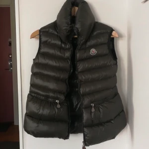 Mocler vest  - Jättefin mörkgrön moncler dunvest perfekt för början av våren! I helt nytt skick, inga skador. Vesten är köpt från Vestiare second hand, ska vara äkta men vet inte och har ej äkthetsbevis där av de låga priset❤️ M i barnstorlek som motsvarar en XS/S❤️ budgivning sker privat 