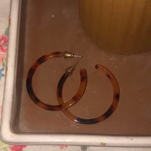hoops, tigeröga  - säljer dessa jättefina hoops i tigeröga mönster. köpta på humana för 110kr men kommer tyvärr inte till användning. allt jag säljer rengörs med sprit innan det packeteras. frakten är 12kr <33