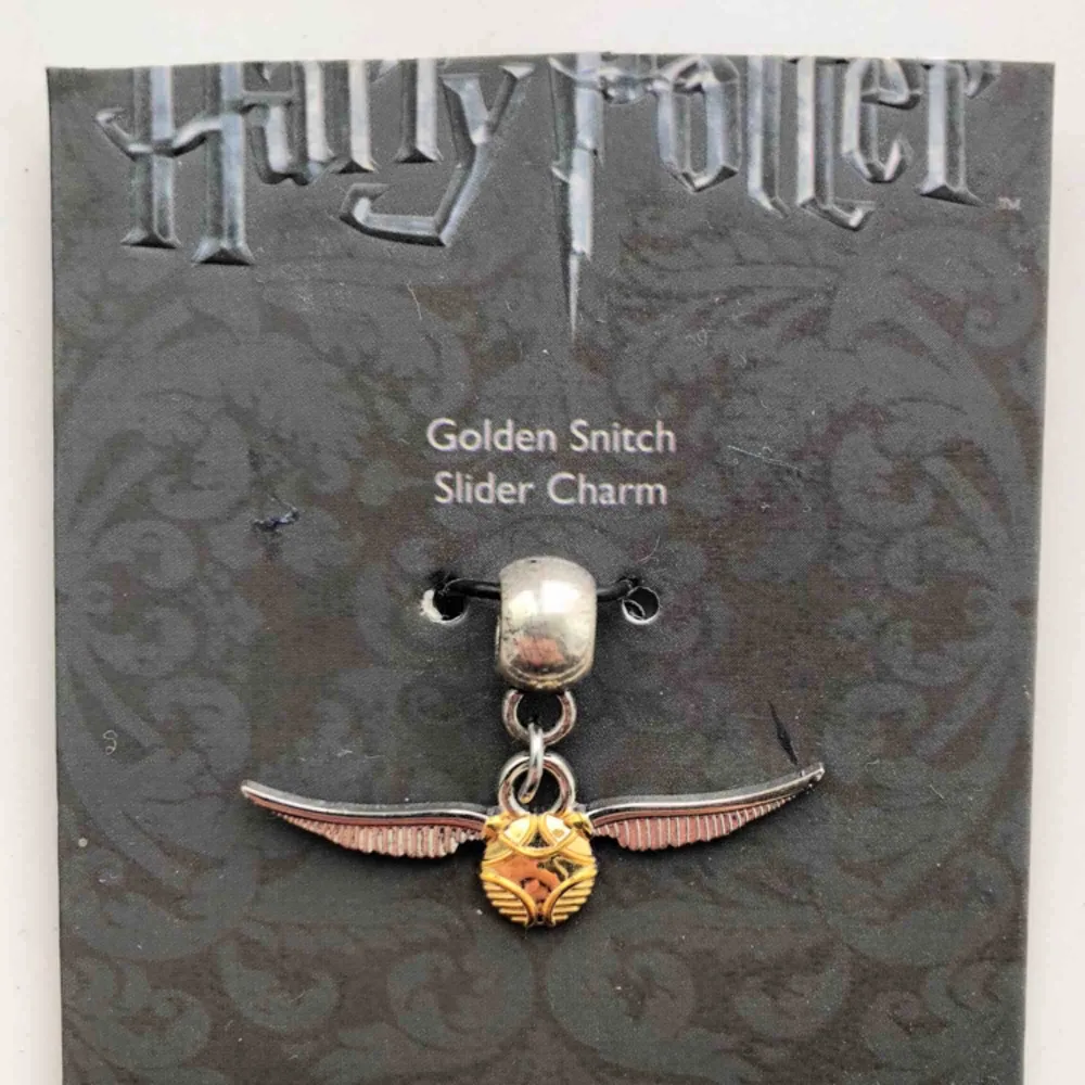 Oanvänd berlock föreställande en golden snitch från Harry Potter-museet i London.. Accessoarer.