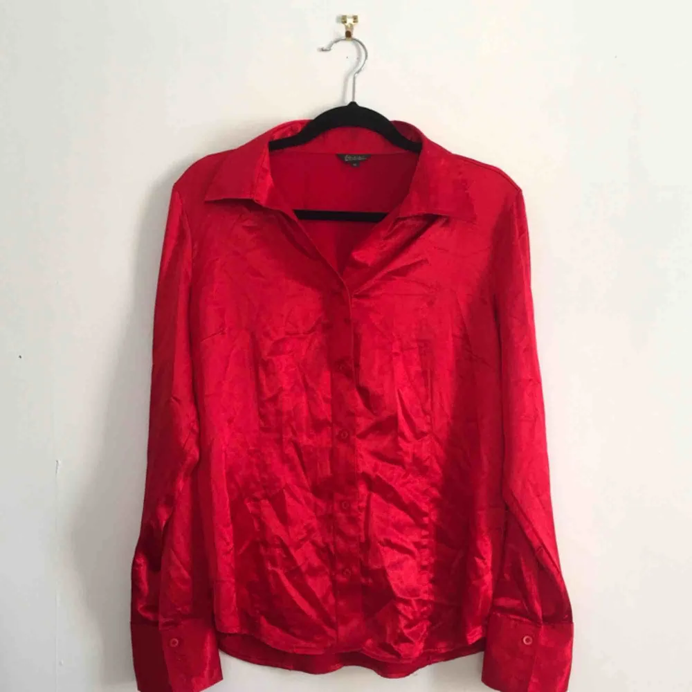 Härlig röd skjorta i siden-liknande material. Köpt secondhand. Möts endast nära Södermalm. Frakt tillkommer. Skriv om du har frågor.. Skjortor.