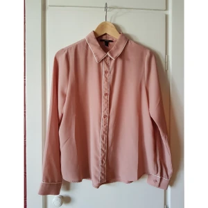  - Tunn rosa skjorta med vita detaljer. Lätt transparant. 