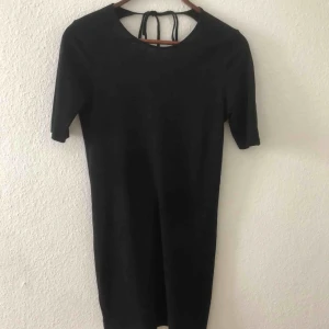 Klänning från Weekday  - En klassisk modell på den lilla svarta. Så 90-tal! Från Weekday. Lagom öppen rygg med knytband. Sparsamt använd för den är så fin. Storlek M. Frakten står du för. 