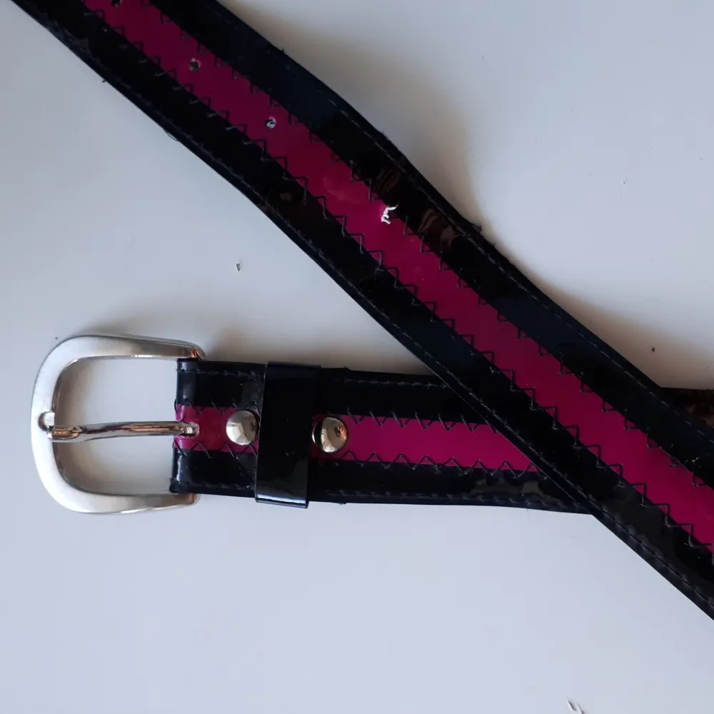 Fin svart bälte med rosa detaljer. Fick den second hand, så den är inte i jätte bra skick (bild 2). Frakt tillkommer. . Accessoarer.