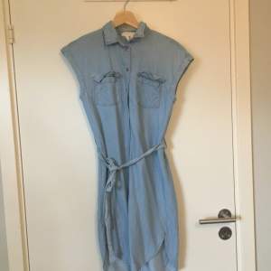 Ljusblå klänning med krage i jeansliknande material från H&M. Stl 32. Gott skick. Frakt betalas av köparen.