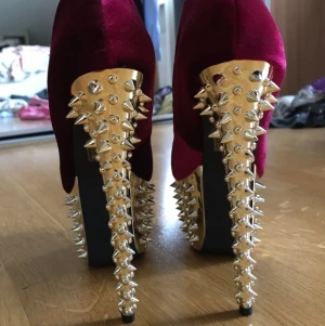 Klackskor med nitar - Röda klackar i sammet med guldprydda nitar. Strl 36 med öppen tå. 