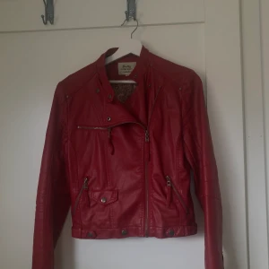 Röd skinnjacka  - Snygg passform och inte för lång utan den slutar precis vid midjan 