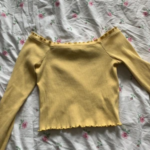Off sholder tröja - Gul tröja från ginatricot, volanger runt alla hål, mat tröja, storlek s liten i armarna köparen står för frakten
