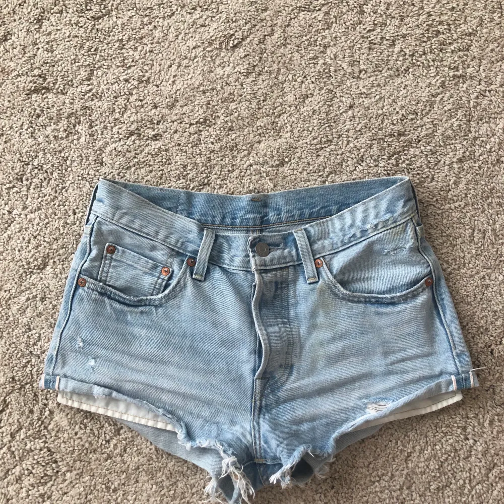 Super fina Levis jeansshorts i ljus tvätt med snygga slitningar. Perfekt nu till sommaren! W26 Köparen står för frakten (63 kr). Shorts.