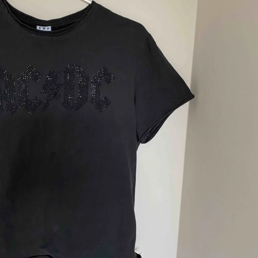 Fmörkgrå/washed black t-shirt från Nelly. Glittrigt AC/DC tryck på. Säljs pga ingen användning 🖤. T-shirts.