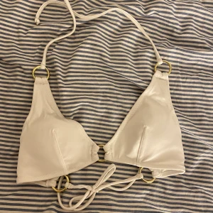 Vit bikini överdel  - Vit bikini överdel med knytning och snygga detaljer med guldringar, köparen står för ev frakt