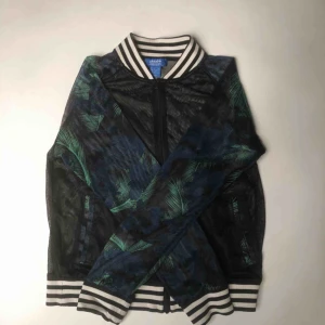  - Adidas tränings kofta. Den är genomskinlig med grönt mönster. Köpte den för 500kr! Använder tyvärr inte längre. Men helt perfekt att träna i! Kom med eget pris! Vill bli av med den 🌹