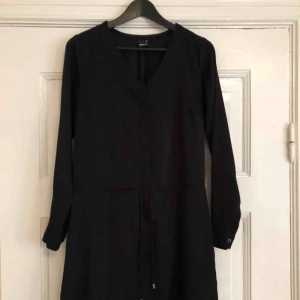  - Svart klänning i bra skick förutom lite noppor på sidorna. 100% polyester. 