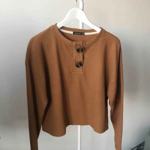  - Oanvänd tröja med knappar upptill.