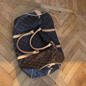Louis Vuitton keepall ”liknande” weekndbag. Har en fläck inuti, se bild, samt är skavd i hörn på undersidan och saknar en ”tass”. Axelrem finns ej kvar