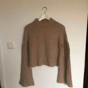 - Stickad tröja i mjukt material från HM trend. Kort krage och med så kallade trumpetarmar. Aldrig använd!