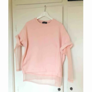  - Ljusrosa avklippt sweatshirt med insydd mesh undertill. Köpt på Asos, använd ett fåtal gånger. Finns ett litet litet märke där fram på tröjan, se tredje bilden. Frakt tillkommer!
