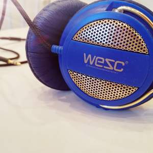 Klarblå och guldiga hörlurar från WESC. Väldigt sparsamt använda.