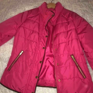  - Jättefin rosa höst eller vinterjacka. Jackan har mörkbruna sömmar och detaljer med guldiga detaljer på både knappar och dragkedjan Storlek L I bra skick, knappt använd Ny pris, 500kr
