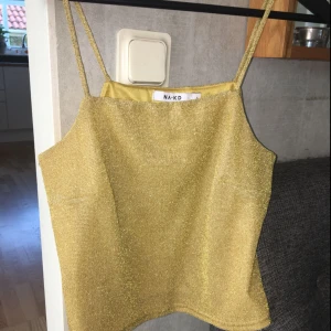  - Glitterlinne guld, i storlek s 40k Bandeau top i guld storlek s 30kr