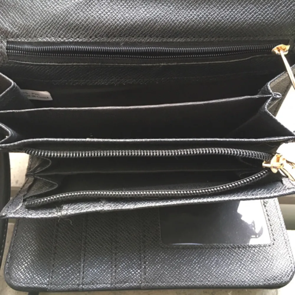 Snygg och enkel liten axelväska/aftonväska med inbyggd plånbok. Kan även användas som clutch då axelremmen är avtagbar.

Väskan är i extremt gott skick, endast använd en gång på kompisars bröllop förra året. Jag har inget behov av väskan och säljer den därför till någon som vill slippa släpa med sig en stor väska ut. 

Två fack för mobil eller nycklar + ett fack med dragkedja. 7 rymliga kortfack + fack för sedlar/mynt med dragkedja. Material i svart fejkskinn. Axelremmen har guldiga detaljer.

Höjd: 11 cm
Bredd: 18,5 cm
Tjocklek utan innehåll 3 cm

Axelremmen är 130 cm (OBS avtagbar)

Jag kan frakta för 30 kr eller mötas upp i Stockholm. 

Tar betalt via swisch, Plick, kontoinbetalning eller kontant.

. Väskor.