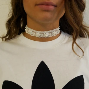 Tyghalsband med pärlor  - Handgjort chokerhalsband i spets med små pärlor. Ställbar storlek.