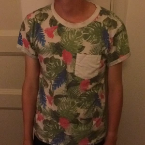  - Snygg bomullströja med blommotiv, har en vit ficka vid bröstet och är mjuk och skön. Snygg också !