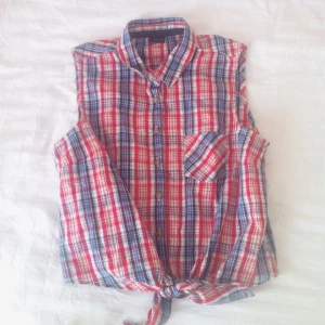  - Söt rutig skjorta i small. Man knyter den som en crop top / mag tröja längst ner. Knappar på skjortan finns också. Bra skick! Frakt betalas av köpare.