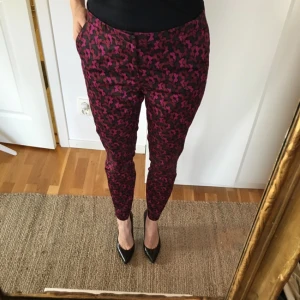  - Snygga byxor från Lindex Missoni-kollektion. Mönster med små fjärilar i lila/cerise på svart botten. Små sprund vid byxsluten. Tunn och skön bomull.