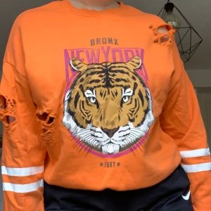 Orange tröja - Orange tröja med ett lejon på. Storlek M men passar större och mindre beroende på gur du vill att den ska sitta. Pris 100kr + frakt🌶