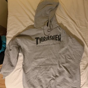 Thrasher hoodie grå - Grå trasher hoodie med svart text som jag säljer! Använt den flertal gånger och den svarta texten är aningen sliten! Men urcool är den😫💕 Frakt ingår i priset och du kan skriva till mig för annat prisförslag!😇