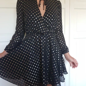 Svårt glittrig omlottklänning - Nice klänning som passar till typ nyår, har resår vid ärmsluten och knyts med band där fram. Frakt ingår!