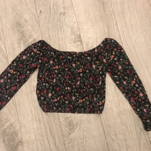 Svart off shoulder blommig crop top - Svart off shoulder blommig crop top. Storlek XS. Vid intresse kan eventuellt fler bilder skickas.