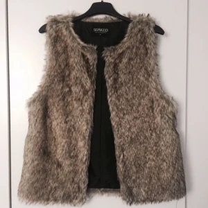  - Pälsväst (fake), Aldrig använd. Ska finnas ett skärp till som inte finns kvar längre.