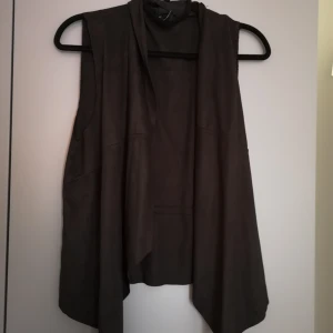 Mockaväst  - Svart väst i mockaimitation från Stradivarius. Jättesnygg över en skjorta, långärmad tröja eller en strapless klänning! 