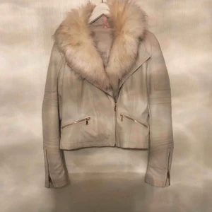  - En fake skinnjacka med pälskrage i storlek L. I utmärkt skick