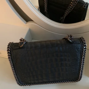 Axelremsväska - Nästan helt oanvänd axelremsväska. Mellanstor