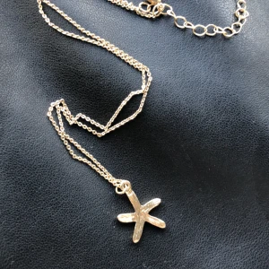 Halsband  - Halsband med sjöstjärna berlock. Har aldrig kommit till använde men otroligt fint. En sida är full av bling och den andra sidan är slät guld plädering. 