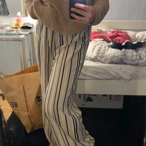Byxor - Ett par svin snygga byxor med ränder på och en dragkedja på sidan🤎 as balla och skit coola! Dem är lite långa för mig och jag är en 157cm! Frakt betalar köparen📦