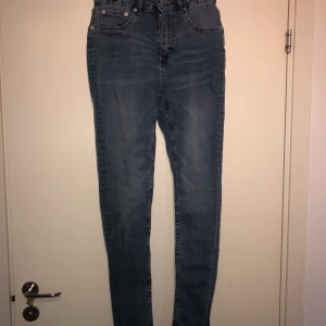 Jeans med slits, stl M - Blå högmidjade jeans med slits i sidan. Långa i benen och stretchiga material, aldrig använda men lapparna är inte kvar. 