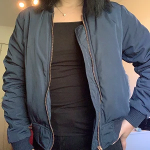 Bomber jacka - En blå bomber jacka med roseguld dragkedja 