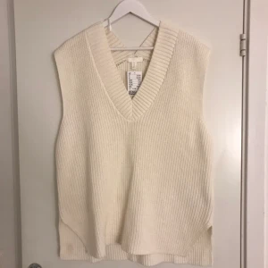 Stickad väst - En stickad väst. Helt oanvänd med lappen kvar.