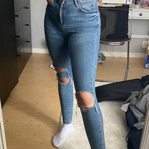 Gina tricot jeans med hål på knäna 💞 Är i storlek 34 men väldigt stretchiga, jag på bilden har i vanliga fall 36/38. Har en liten lila fläck som knappt synd på höger lår. Har ej testat något mycket för att få bort den.🖤
