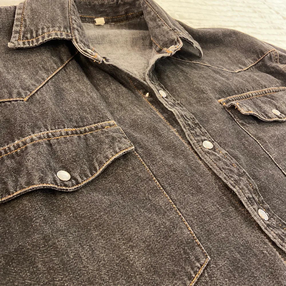 Kort svart/grå jeansjacka med relativt korta men breda ärmar. Jeansmaterialet är ganska tunt men det går att ha tjockare tröjor under då jackan är bred och luftig.. Jackor.
