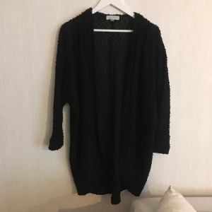  - Svart oversized kofta i ”nopprigt” bomull. Lite längre i ryggen än framtill.  Köparen står för frakten! Kan även hämtas upp i Göteborg!